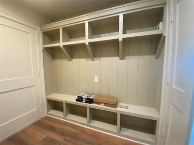 Mudroom with wood walls and dark wood-type flooring