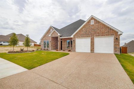 View of front facade featuring a front lawn and a garage