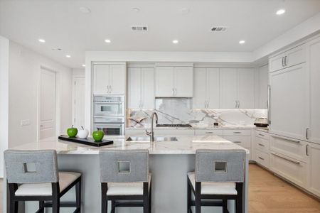 Gourmet kitchen with center island and pull-out seating. Custom cabinetry with under cabinet lights, gorgeous countertops and upscale appliances by Thermador and Sub-Zero.