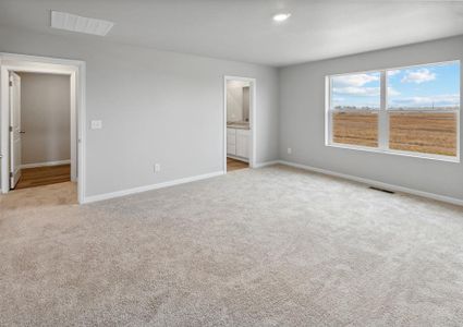 Expansive master bedroom with large windows and attached bathroom.
