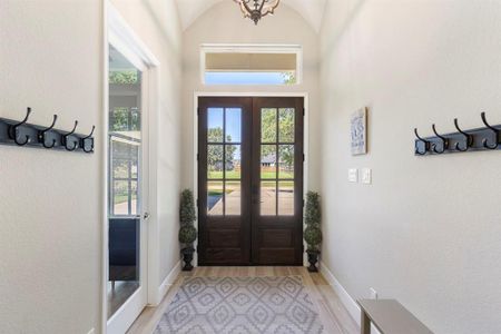 Entryway has plenty of hooks for guests to hang their jackets/purses on and off to the left is the office with a glass door.