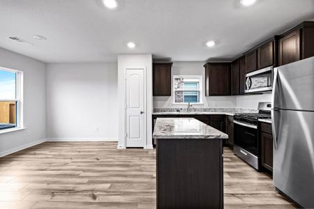 Kitchen featuring appliances with stainless steel finishes, a center island, plenty of natural light, and light hardwood / wood-style flooring