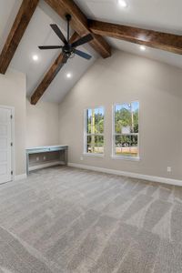 Unfurnished living room featuring high vaulted ceiling, beam ceiling, ceiling fan, and carpet floors