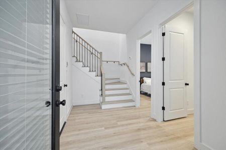 Upon entry, guests are welcomed through stained engineered wood flooring that extends throughout the entire home. Oversized case openings offer white doors and trim are contrasted with elegant black hardware at every opening.