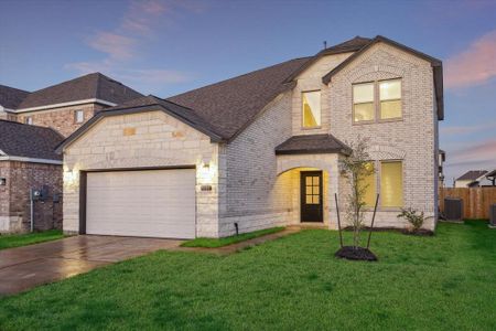 Another angle of this beautiful home shows off its graceful architecture, highlighting the mix of stone and brickwork, creating a warm yet modern look. The elegant archway invites you into the spacious interior.