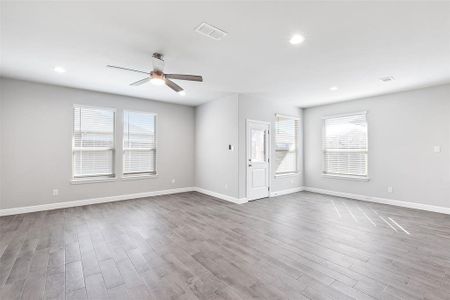 Unfurnished living room featuring hardwood / wood-style flooring and ceiling fan