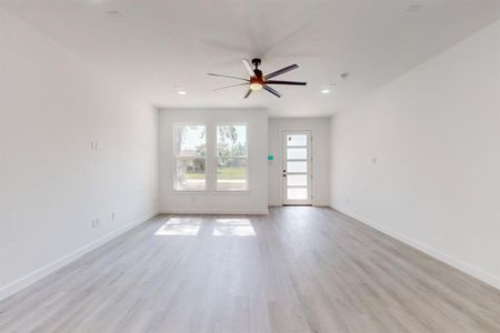 Empty room with ceiling fan and light wood-type flooring