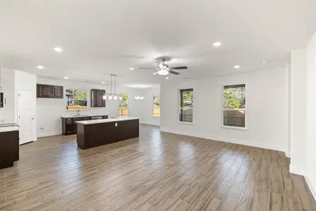 Kitchen featuring dark brown cabinets, decorative light fixtures, a center island, and light hardwood / wood-style floors