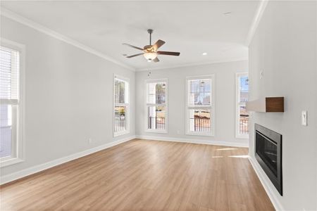 The large windows allow natural light to filter into the room, highlighting the warmth of the hard surface floors. NOT actual home. Photos of previously built Grayton floorplan.