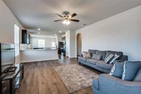 Living room with ceiling fan and hardwood / wood-style flooring