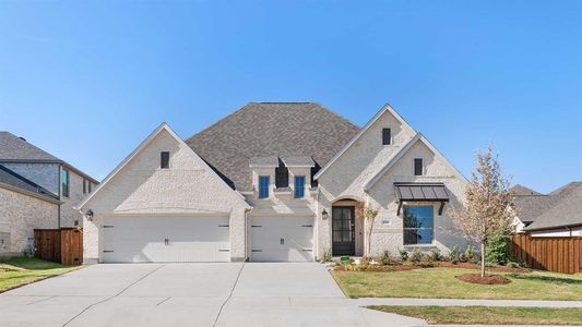 French country style house featuring a front lawn and a garage