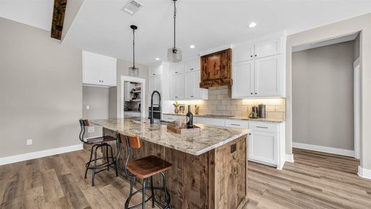 Kitchen with a kitchen island, beautiful wood vent hood