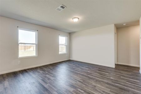 Spare room with dark hardwood / wood-style floors and plenty of natural light