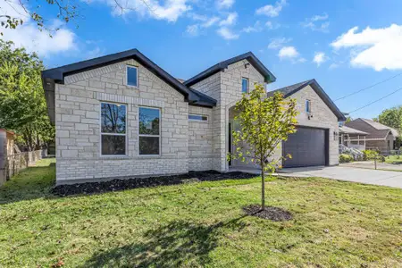 View of front facade featuring a garage and a front yard