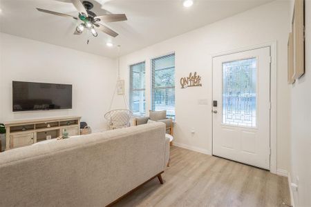 Living room featuring ceiling fan and light hardwood / wood-style flooring