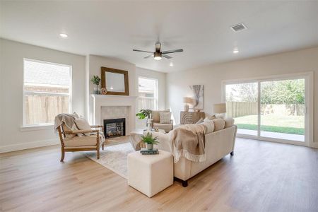 The living spacious living room has 9 foot ceilings, luxury vinyl flooring, and is anchored by a fireplace at the heart of the room