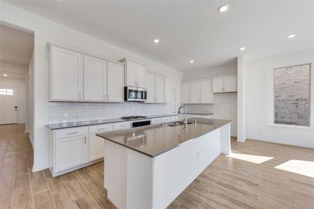 Kitchen with sink, appliances with stainless steel finishes, and white cabinetry