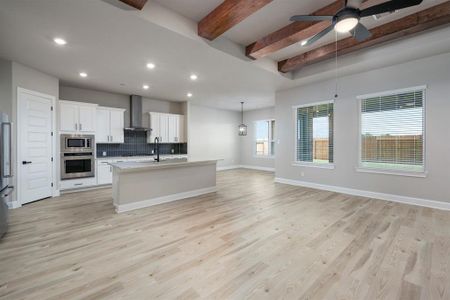 High ceilings and open space greet you in this beautiful family room with wooden beams and gorgeous flooring.
