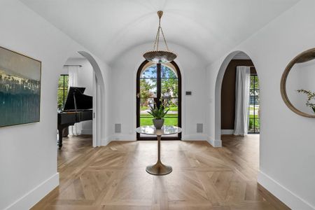 Foyer entrance featuring light parquet flooring and lofted ceiling