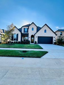 French provincial home featuring a garage and a front lawn