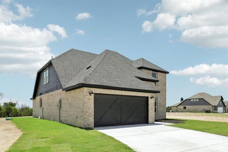 View of side of home with a garage and a lawn