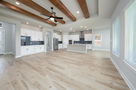The large family room adjacent to the kitchen creates a unified social space, fostering seamless interaction and connectivity between family members and guests, whether relaxing, cooking, or entertaining.