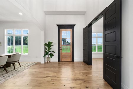 White oak floors greet you in the two-story foyer; office beyond the double doors; formal dining beyond the cased opening. *Virtually staged.