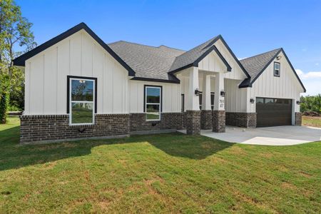 Modern farmhouse with a front lawn and a garage