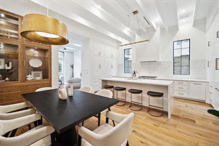 The masterful open kitchen impresses with stunning custom cabinetry features brass Emtek hardware and a Zellige tile backsplash.