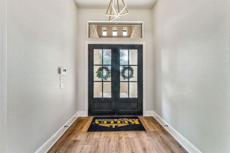 Doorway with hardwood / wood-style flooring and french doors