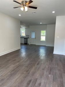 Unfurnished living room featuring ceiling fan, dark hardwood / wood-style floors, and sink