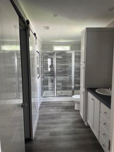 Bathroom featuring vanity, an enclosed shower, hardwood / wood-style floors, and toilet