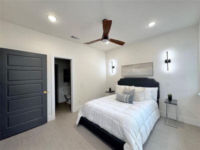 Bedroom featuring light hardwood / wood-style flooring, ceiling fan, and a spacious closet