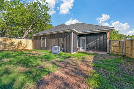 Back of house featuring cooling unit and a yard