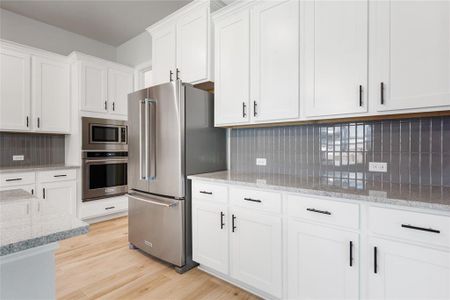 The kitchen comes equipped with upgraded, Kitchen Aid stainless steel appliances, a gorgeous center island, and French-door refrigerator.