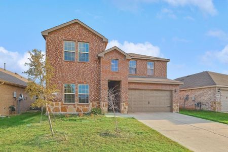 View of property featuring a garage and a front lawn