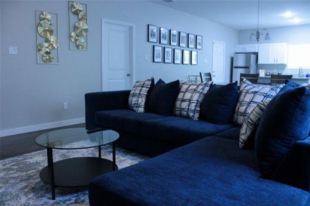 Living room with a notable chandelier, hardwood / wood-style floors, and sink