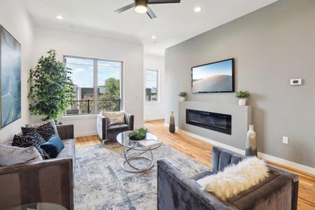 Living room with light hardwood / wood-style floors and ceiling fan