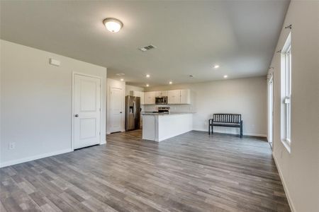 Kitchen with light hardwood / wood-style flooring, white cabinetry, kitchen peninsula, and appliances with stainless steel finishes