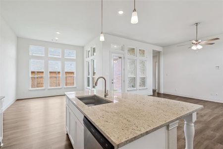 Kitchen with sink, decorative light fixtures, white cabinetry, dishwasher, and hardwood / wood-style flooring