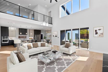 Living room featuring a healthy amount of sunlight, a high ceiling, and light wood-type flooring