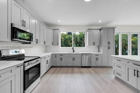 STUNNING KITCHEN W/ ENERGY SAVING FRIGIDAIRE APPLIANCES, CUSTOM CABINETS W/ QUARTZ COUNTERS, CENTR ISLAND, ALL OVER LOOKING THE GREAT ROOM W. VIEWS TO THE OUTSIDE FRONT & BACK