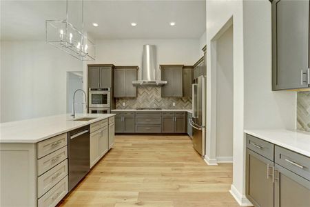 The kitchen has a sprawling center island with undermount stainless steel sink, push button garbage disposal, and Moen faucets.