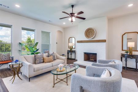 Living room featuring ceiling fan, hardwood / wood-style flooring, and a fireplace