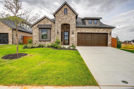 View of front of home featuring a garage and a front lawn