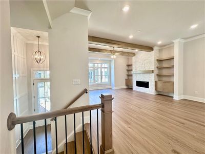 Living room is situated in the front of the home showcasing custom beams with custom built-ins both stained on site