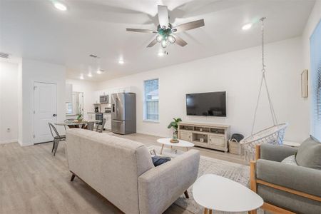 Living room featuring ceiling fan and light hardwood / wood-style flooring