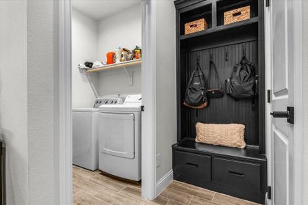 Laundry area with washing machine and clothes dryer and wood-type flooring