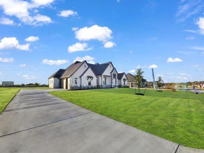 View of front facade featuring a front yard and a garage