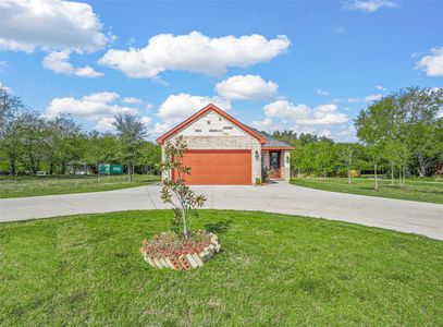 View of front of house featuring a front yard, garage, and circle drive.